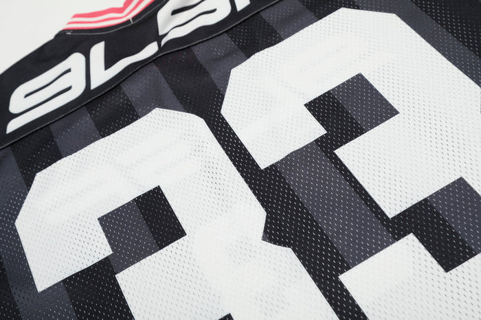 Close-up of black and white football jersey with number 33 and bold sport chain graphic detailing