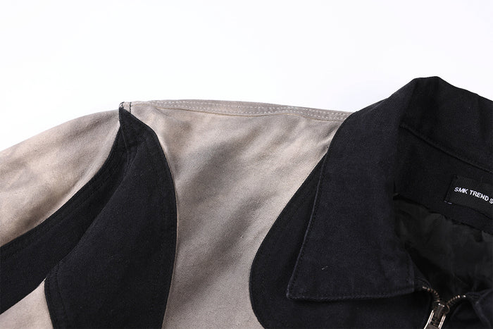 Close-up of the jacket shoulder and pointed black collar with contrasting grey and black patchwork panels