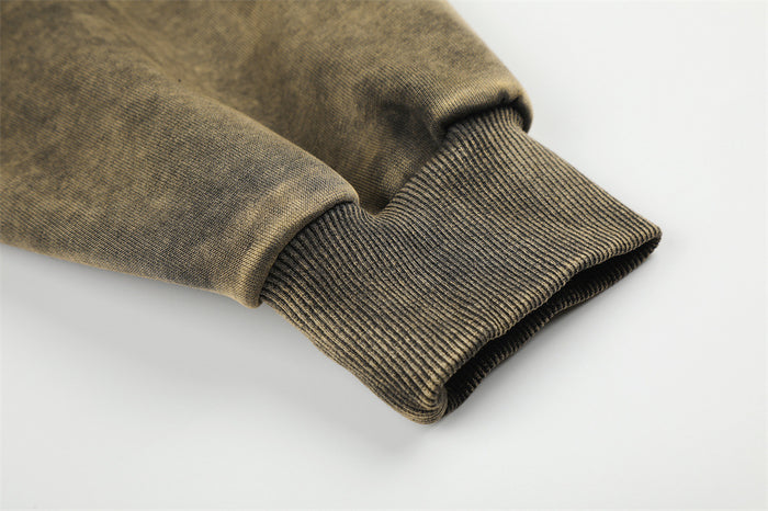 Close-up of a ribbed sleeve cuff meeting the dark acid-wash hoodie fabric