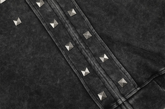 Detail of pyramid studs lining the black acid-washed hoodie zipper placket