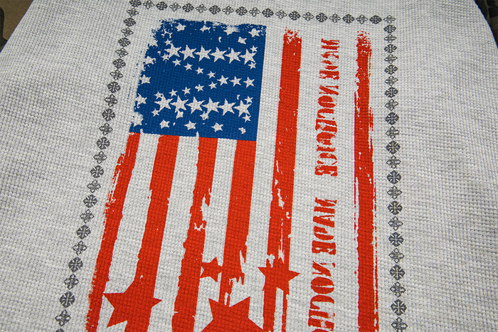 Close-up of distressed blue and red American flag graphic printed on gray waffle-knit fabric