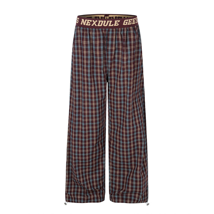 Front view of burgundy plaid wide-leg pants with elastic waistband and drawcord hems