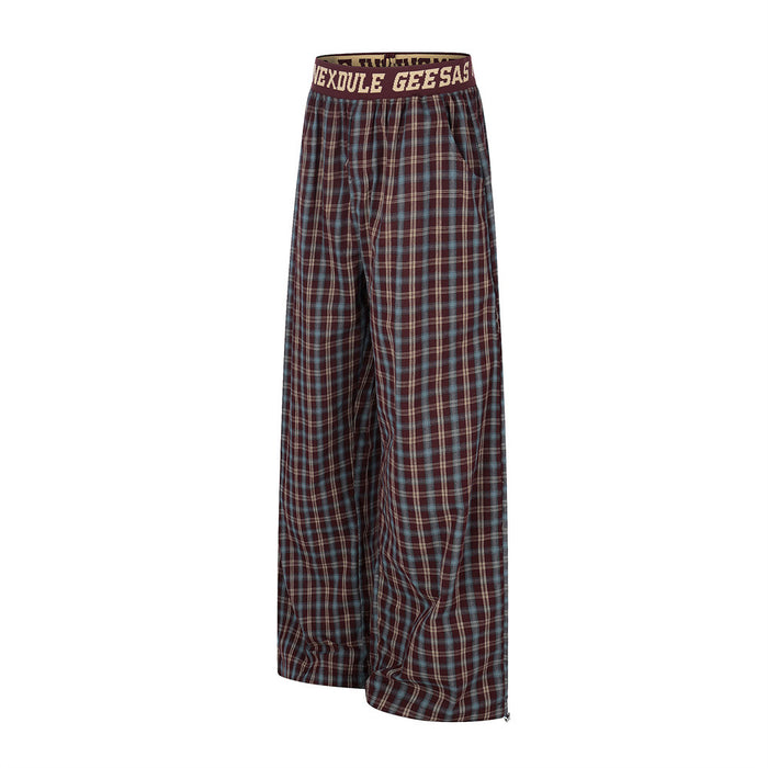 Side view of burgundy plaid wide-leg pants with relaxed drape and elastic waist