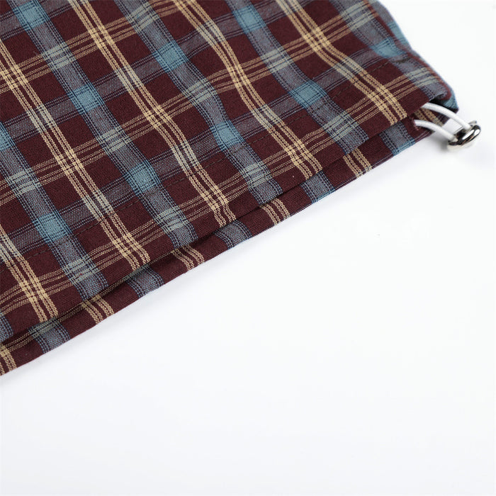 Close-up of plaid pant hem with drawcord stopper and layered cuff detail
