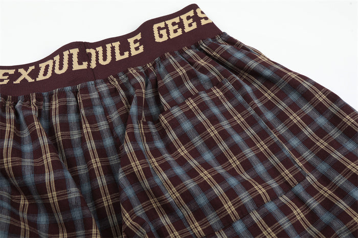 Top view of burgundy plaid pants showing gathered waistband and loose pleats