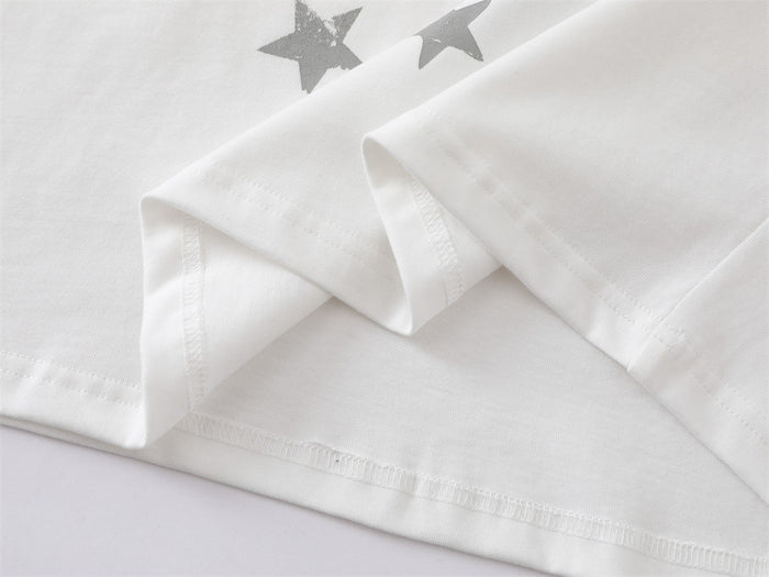 Close-up of white T-shirt hem with stitching and star print detail