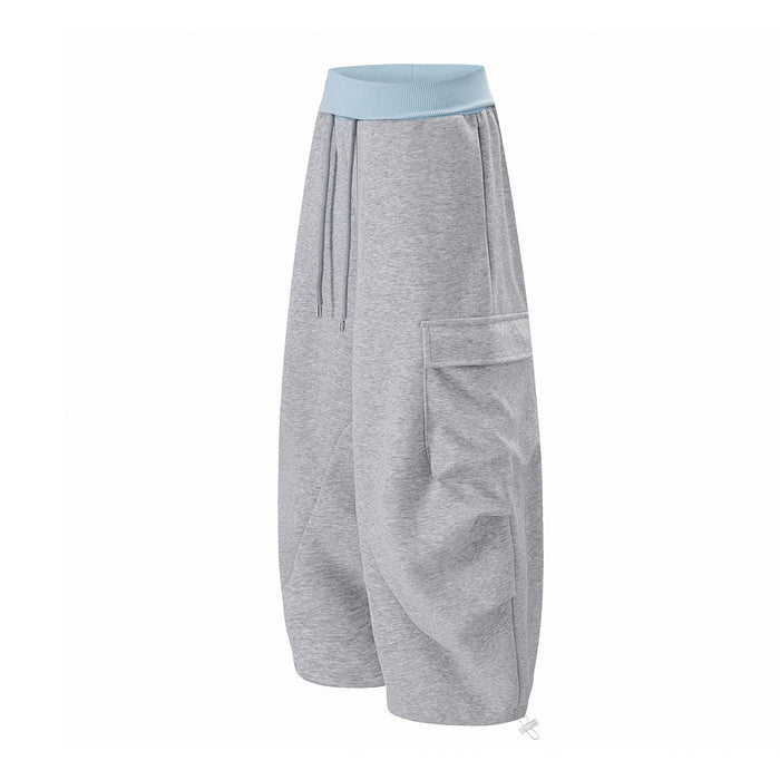 Three-quarter view of gray wide-leg cargo sweatpants showing the drawstring waist and side flap pocket