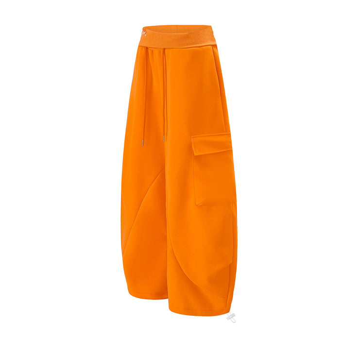 Three-quarter view of bright orange cargo sweatpants showing the drawstring waist and layered side pockets