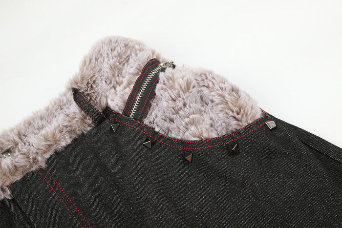 Detail of the black jeans front waistband with plush beige lining, zipper closure, red stitching, and metal studs