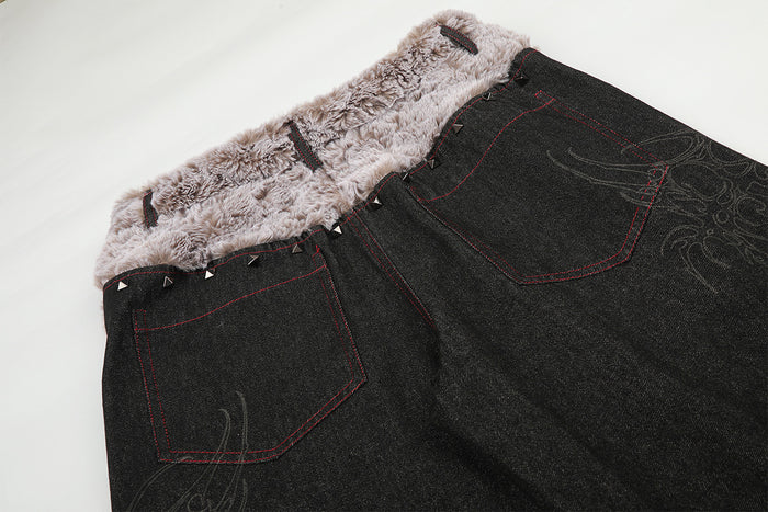Close-up of the jeans back showing the plush beige waistband, red-stitched pockets, and subtle embroidered design