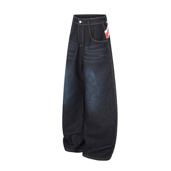 Side view of dark wide-leg jeans showing the curved leg shape, front pocket and partial Union Jack detail