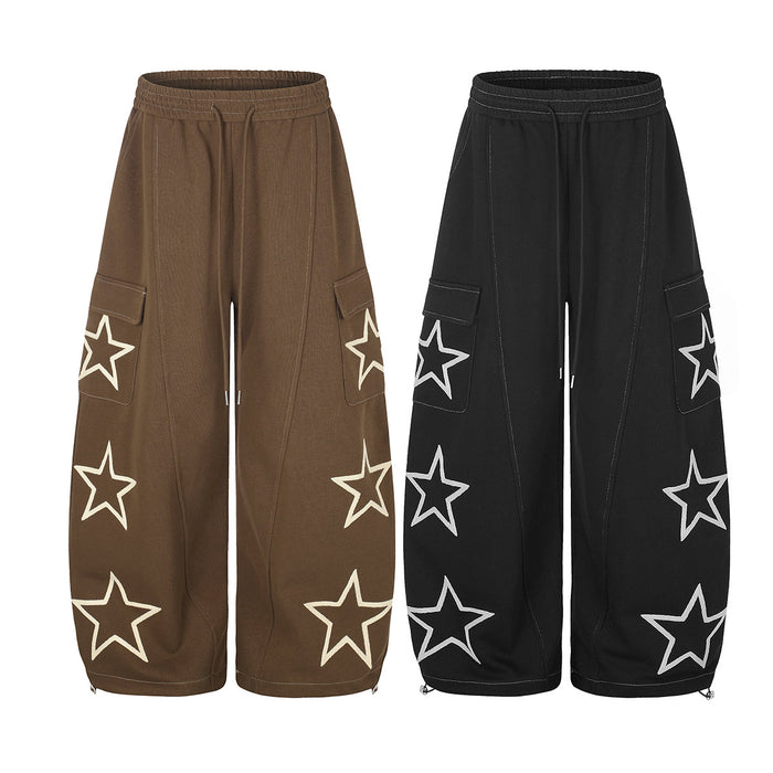Front view of wide-leg cargo sweatpants in brown and black with outlined star graphics and drawstring waists