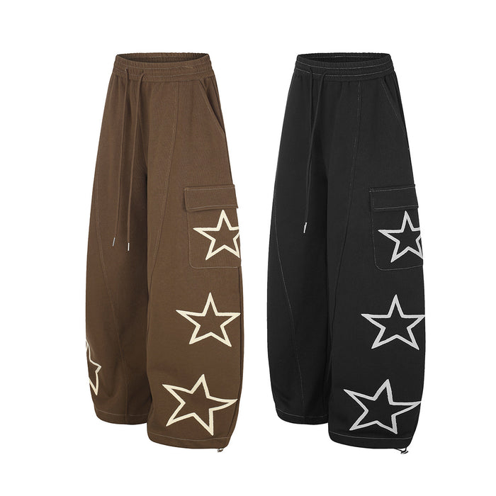 Angled front view of brown and black wide-leg cargo sweatpants with star graphics and flap pockets