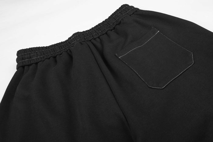 Close-up of black sweatpants waistband and stitched rear patch pocket