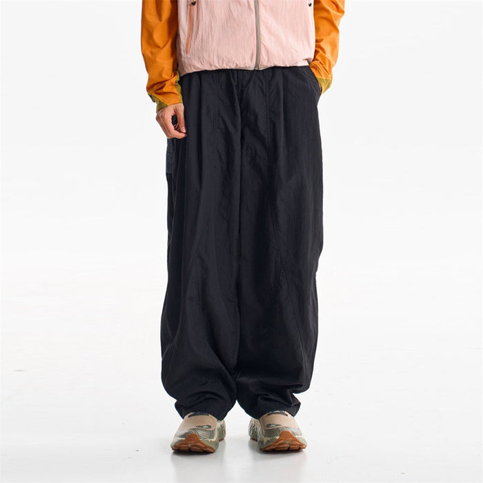Unisex oversized wide-leg parachute pants in midnight black with elastic waist and cinched ankle cuffs