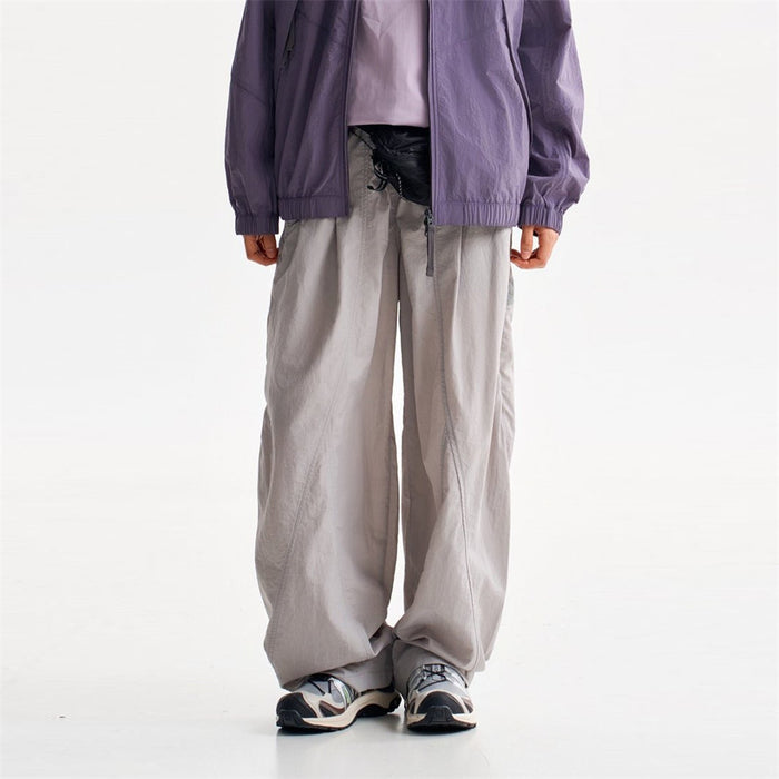 Light gray baggy pants shown from the front with an elastic waistband and loose straight legs