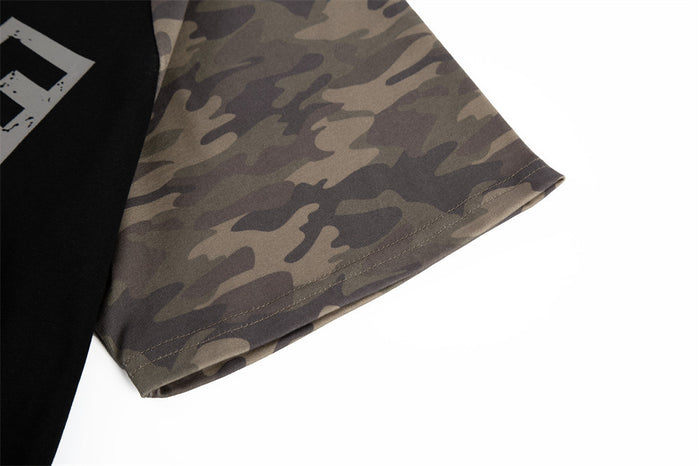 Close-up of a black and camo raglan T-shirt sleeve with color block design on a white background