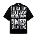 Black oversized graphic T-shirt with bold distressed white text print and relaxed hip hop streetwear style
