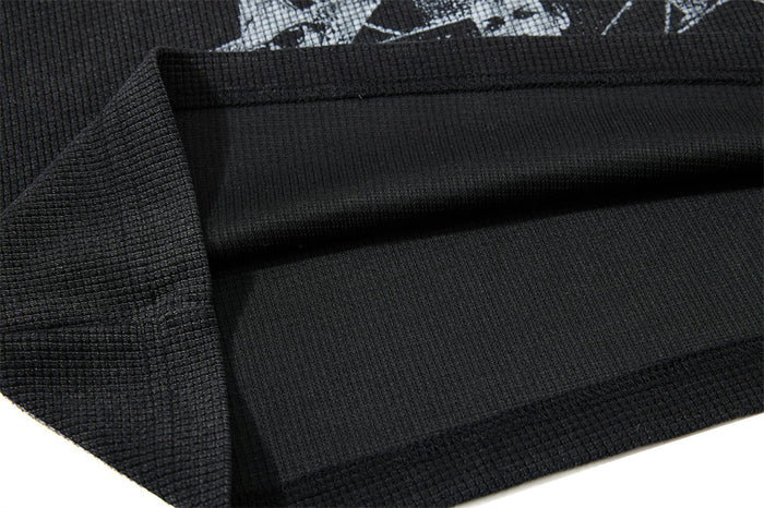 Close-up of the black waffle knit shirt interior, folded hem, and stitched bottom seam