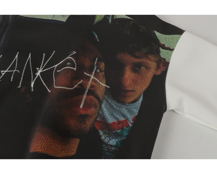 Close-up of the front graphic on black and white hoodie, showing faces and scribble text