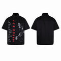 Black short-sleeve button-up shirt with rock guitarist graphic, red stars, and inspirational quote on the front panel