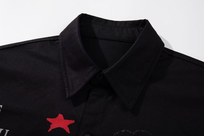 Close-up of a black button-up shirt collar with red graphic print on the chest, streetwear style
