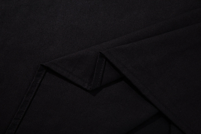 Close-up of black button-up shirt fabric with folded seams and subtle texture, styled for rock-inspired streetwear