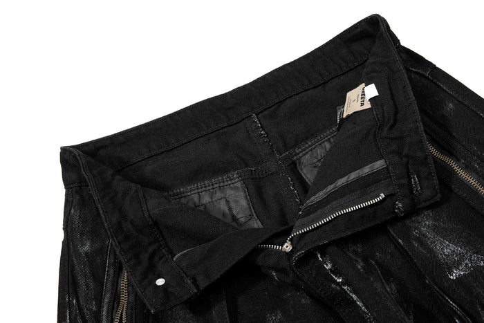 Inside waistband close-up showing lining, zipper, and care label on black denim