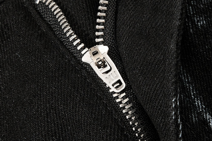 Close-up of silver zipper pull on black washed cargo denim