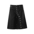 Black washed denim wide-leg shorts with diagonal silver snap-button placket and contrasting white topstitching, front view