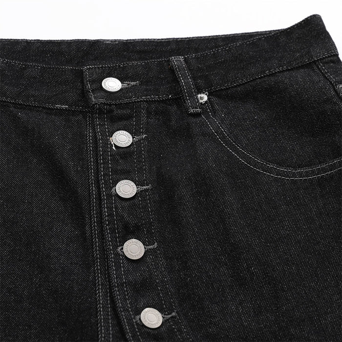 Close-up of black denim shorts front with silver button closure