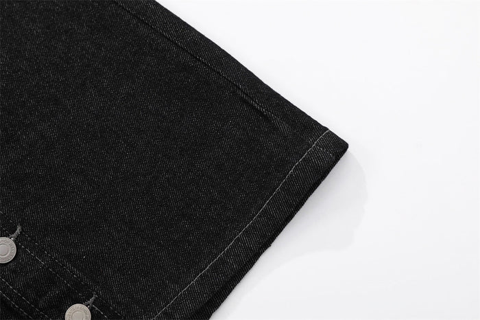 Close-up of black denim shorts hem with stitched cuff edge
