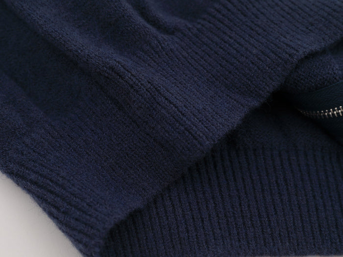 Close-up of navy knit fabric texture on the varsity jacket