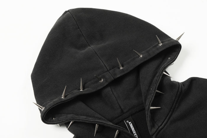 Close-up of the black hood lined with fabric and decorated with silver metal spikes around the edge
