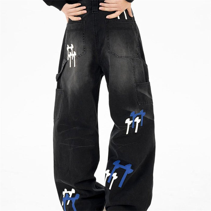 Back view of black wide-leg cargo jeans with rear pockets, cargo pockets, and cross embroidery patches