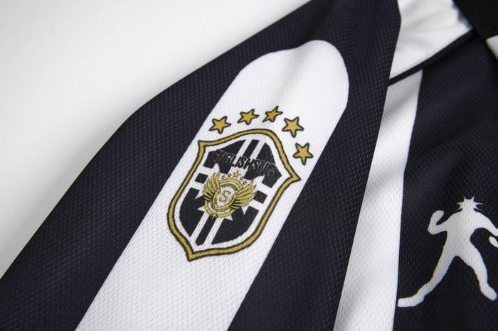 Close-up of a black and white jersey stripe featuring an embroidered shield emblem with gold star details