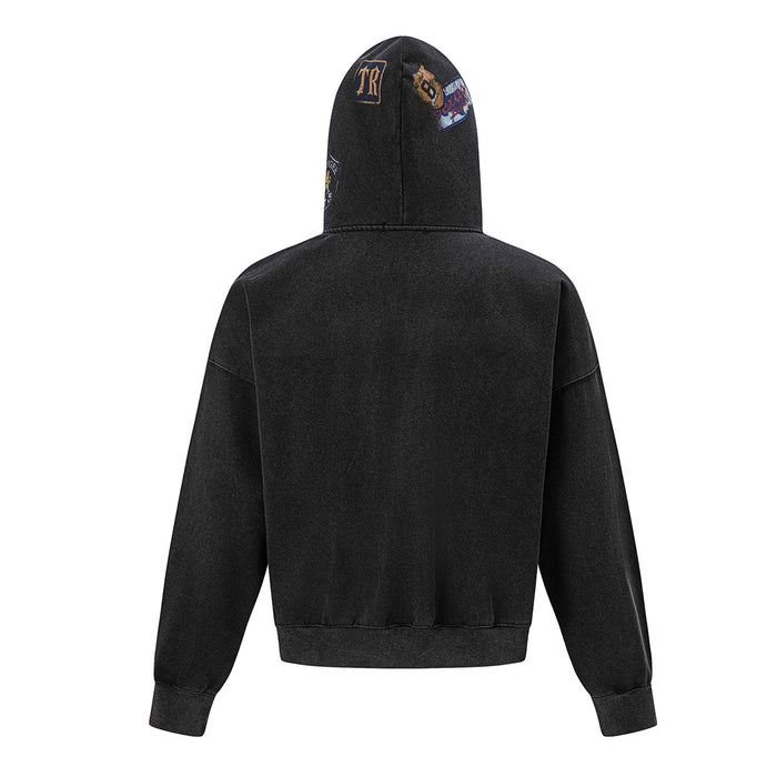 Back view of the black acid-wash zip-up hoodie with embroidered patches on the hood and ribbed hem