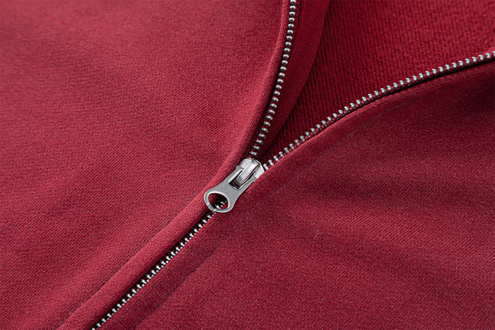 Close-up of the silver zipper slider and teeth on the red hoodie