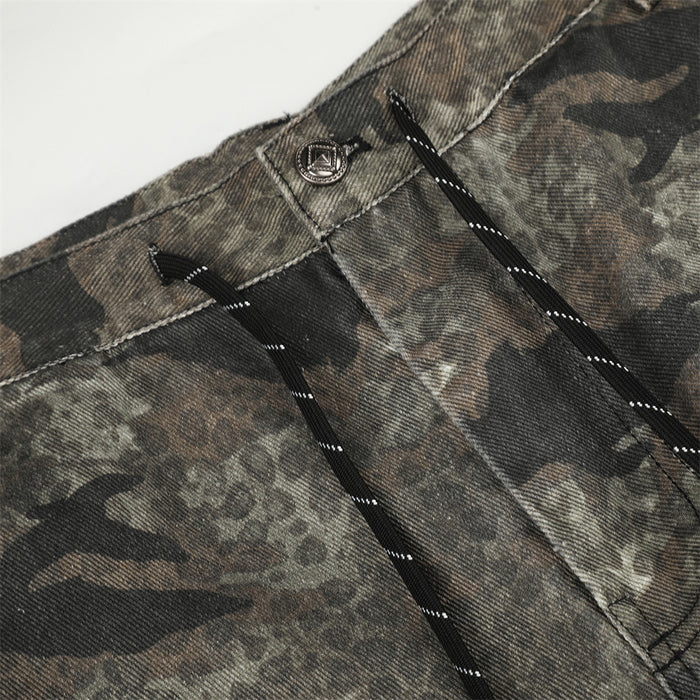 Close-up of camouflage pants button closure and black-trimmed drawstring fly