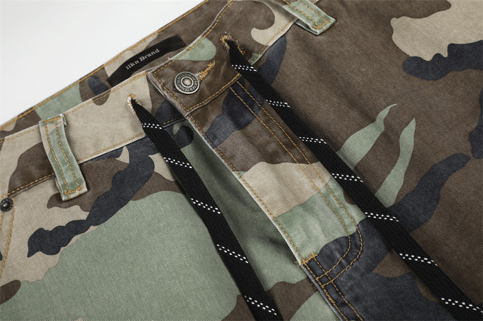Detailed view of waistband, button closure, and black drawstring on camo pants