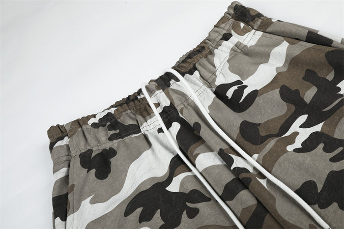 Close-up of camouflage sweatpants waistband with white drawstring and stitching