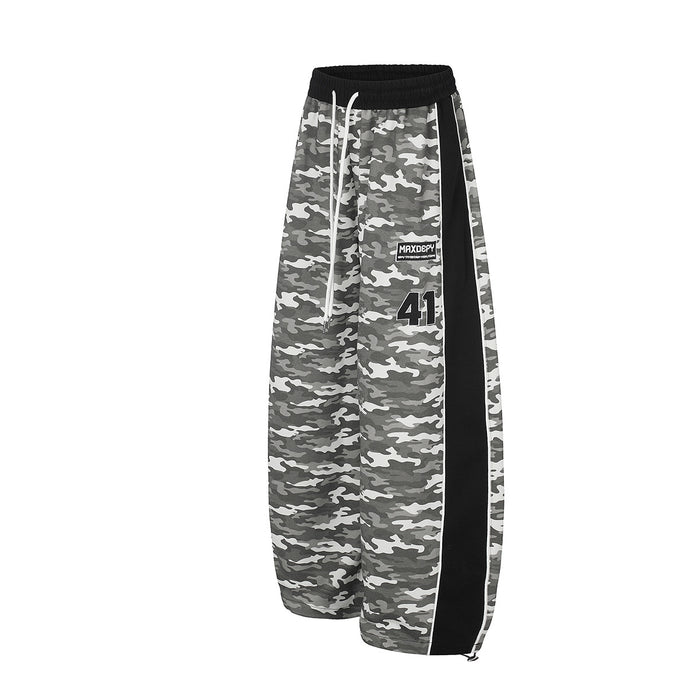 Angled front view of gray camouflage wide-leg sweatpants with black side panel and white drawstring