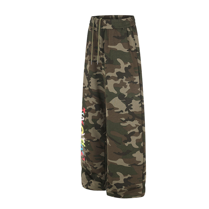 Side view of wide-leg camouflage sweatpants showing the relaxed silhouette and partial colorful leg graphic