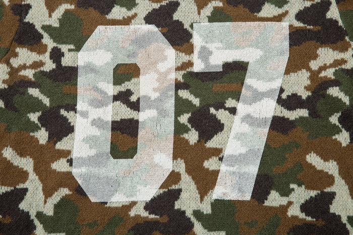 Close-up of the large 07 graphic on the back of a camouflage knit hoodie