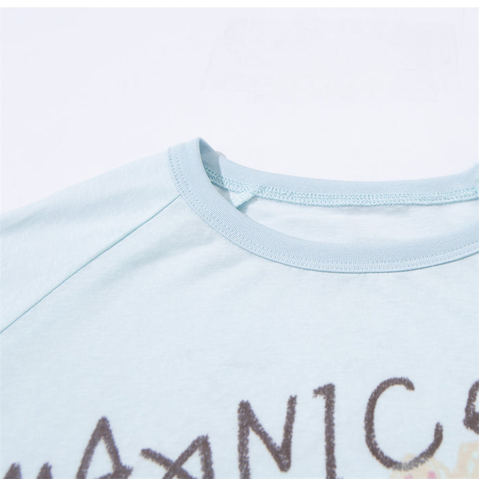 Close-up of the light blue shirt’s ribbed crew neckline and partial hand-drawn front graphic