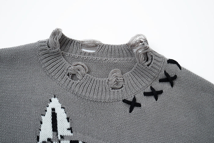 Close-up of gray knit sweater crew neck with distressed loops, ribbed collar, and black stitched X accents