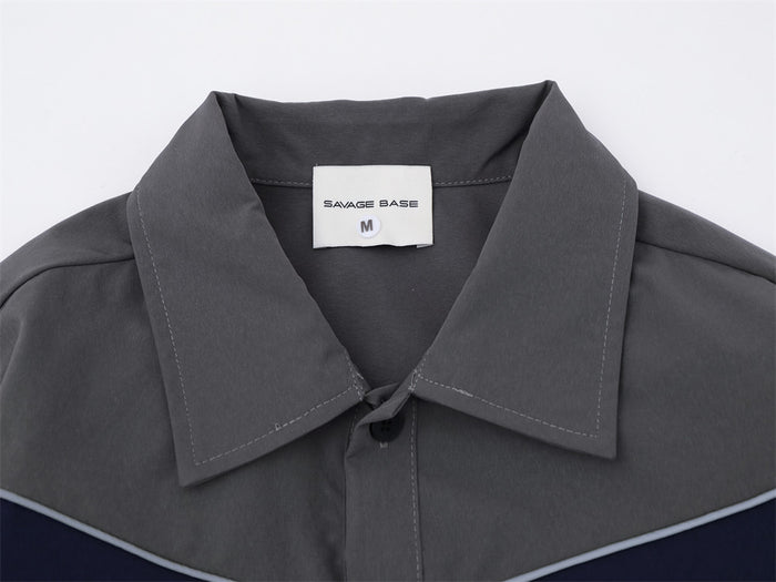 Close-up of the gray shirt collar showing the pointed design, top button, contrast stitching, and neck label