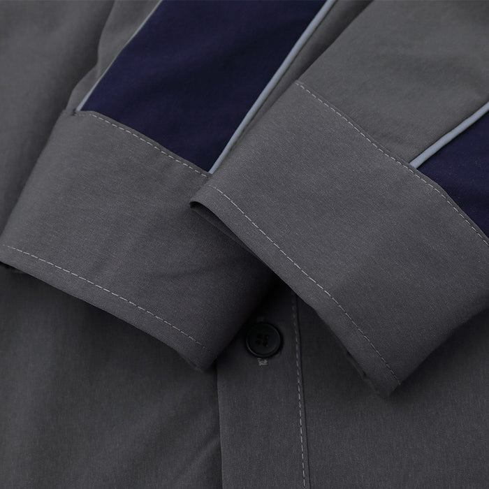 Close-up of the gray sleeve showing navy contrast panel, light piping, stitched cuff, and black button