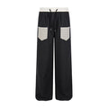 Black plaid wide-leg pants with white waistband and contrast plaid front pockets, front view