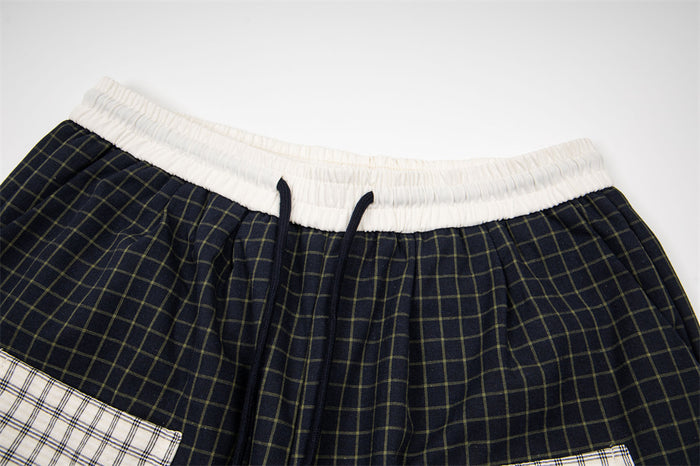 Close-up of black plaid pants waistband with white elastic trim and drawstring